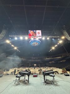 Lively dueling pianos performance engaging the audience at Sames Auto Arena