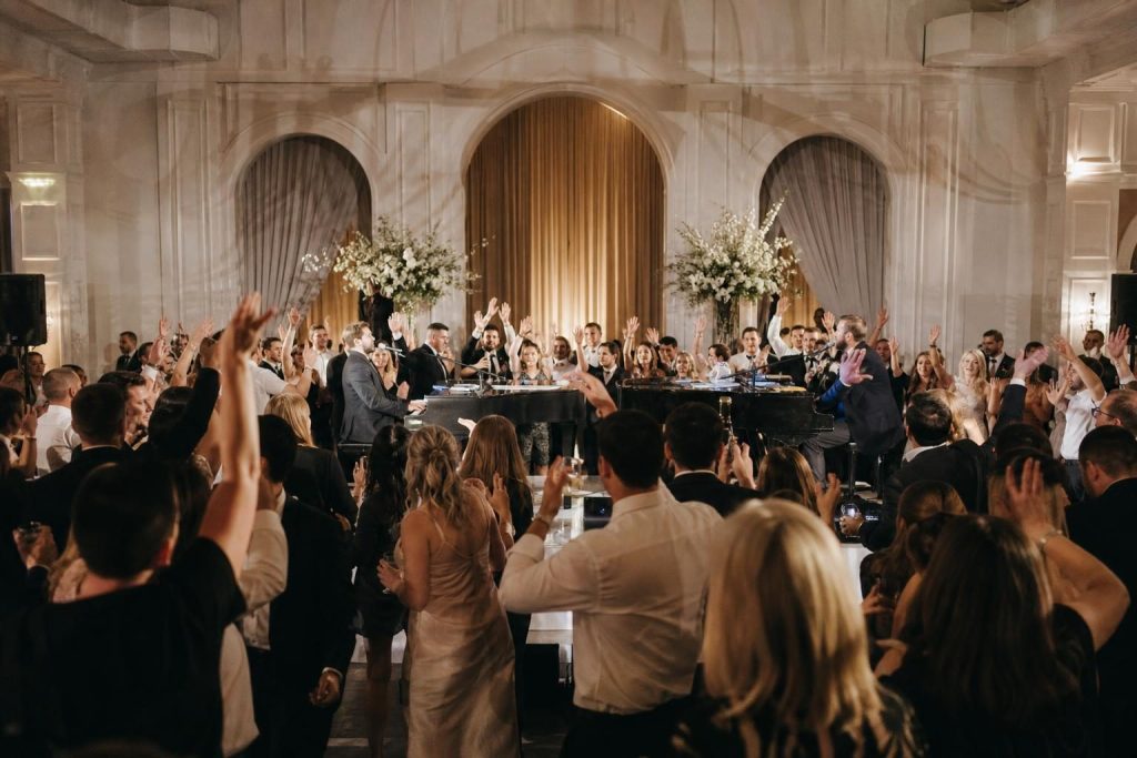Guests enjoying interactive piano entertainment at a wedding reception